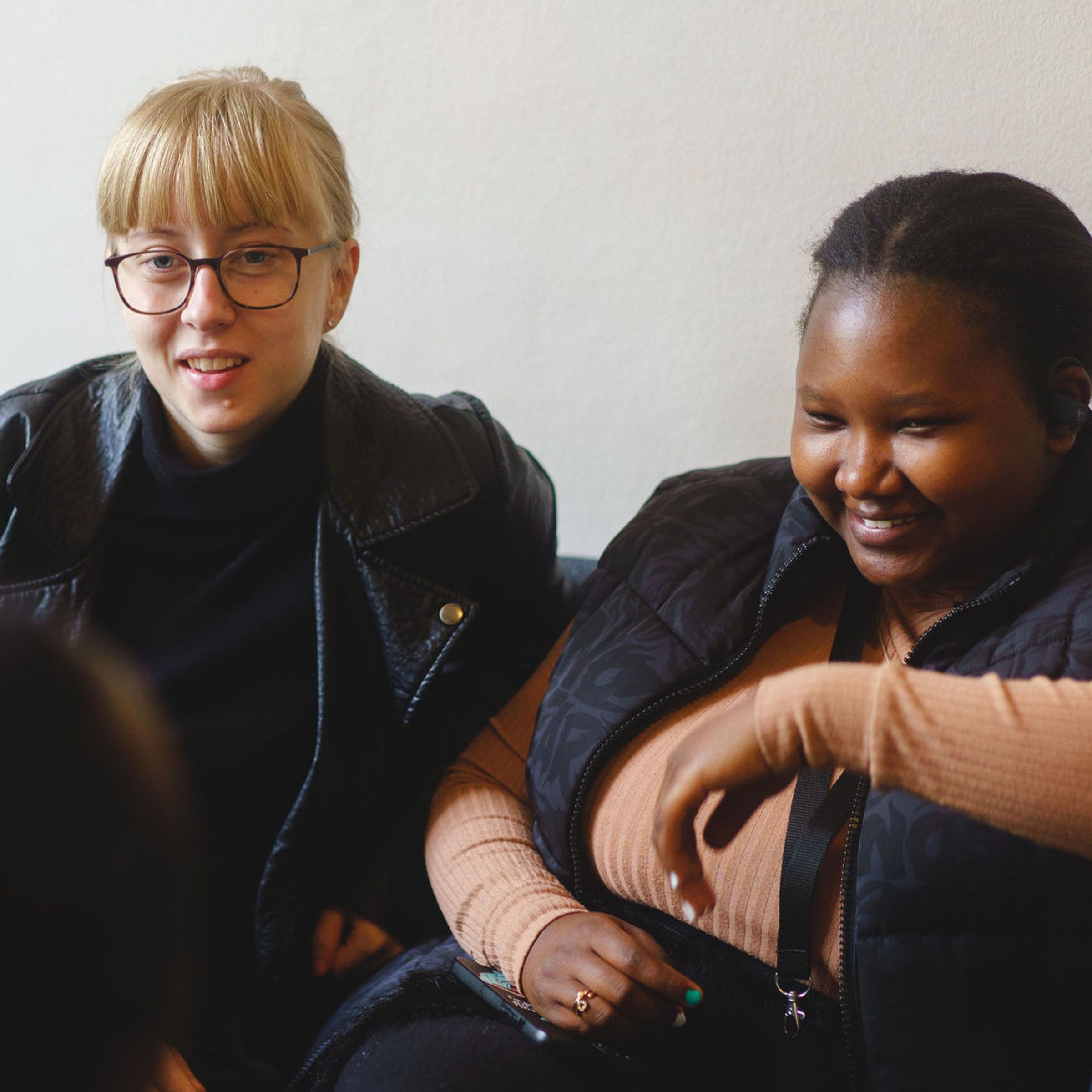 Två kvinnor sitter i en soffa och pratar med varandra