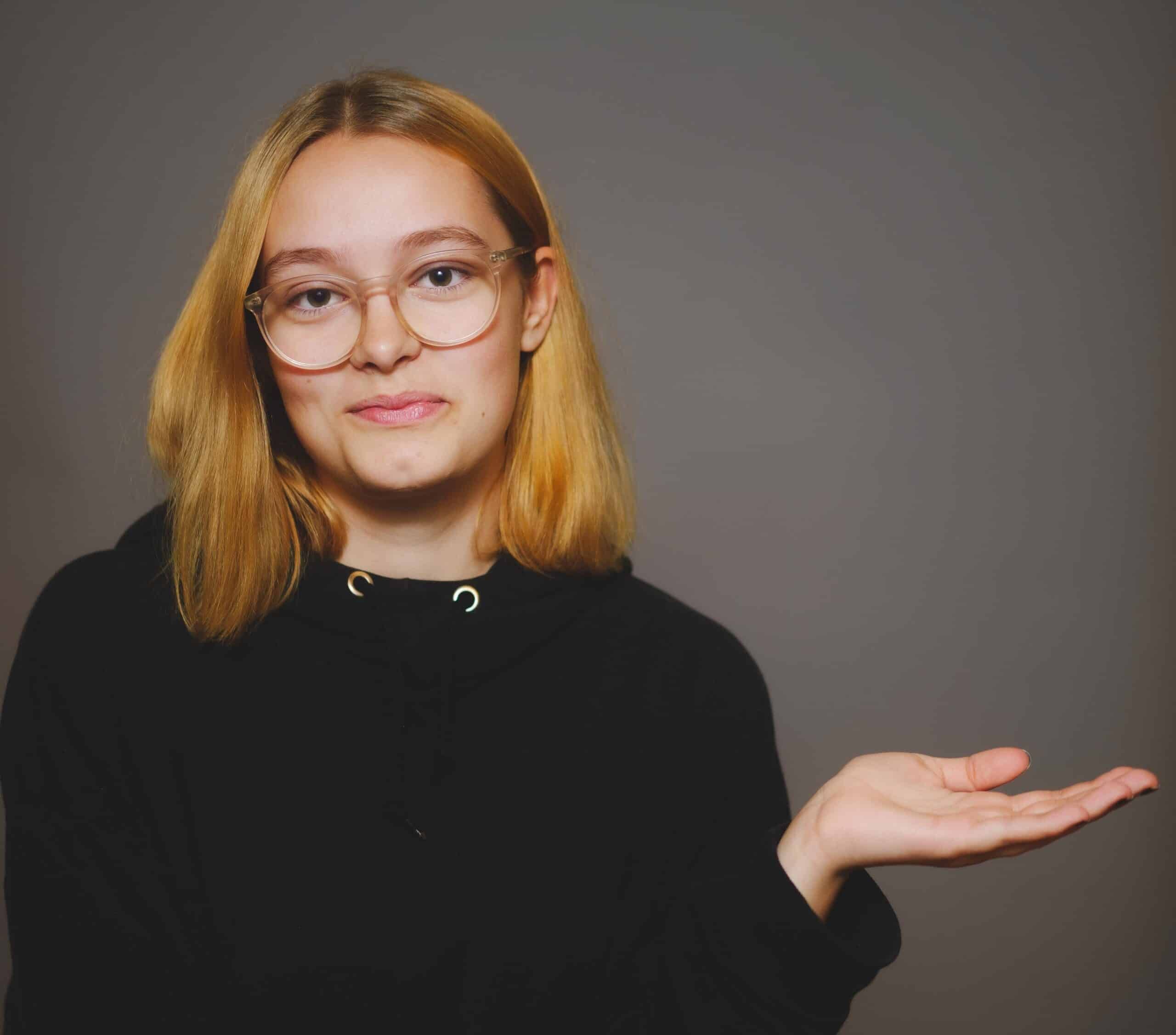 En tjej som gestikulerar åt sidan.