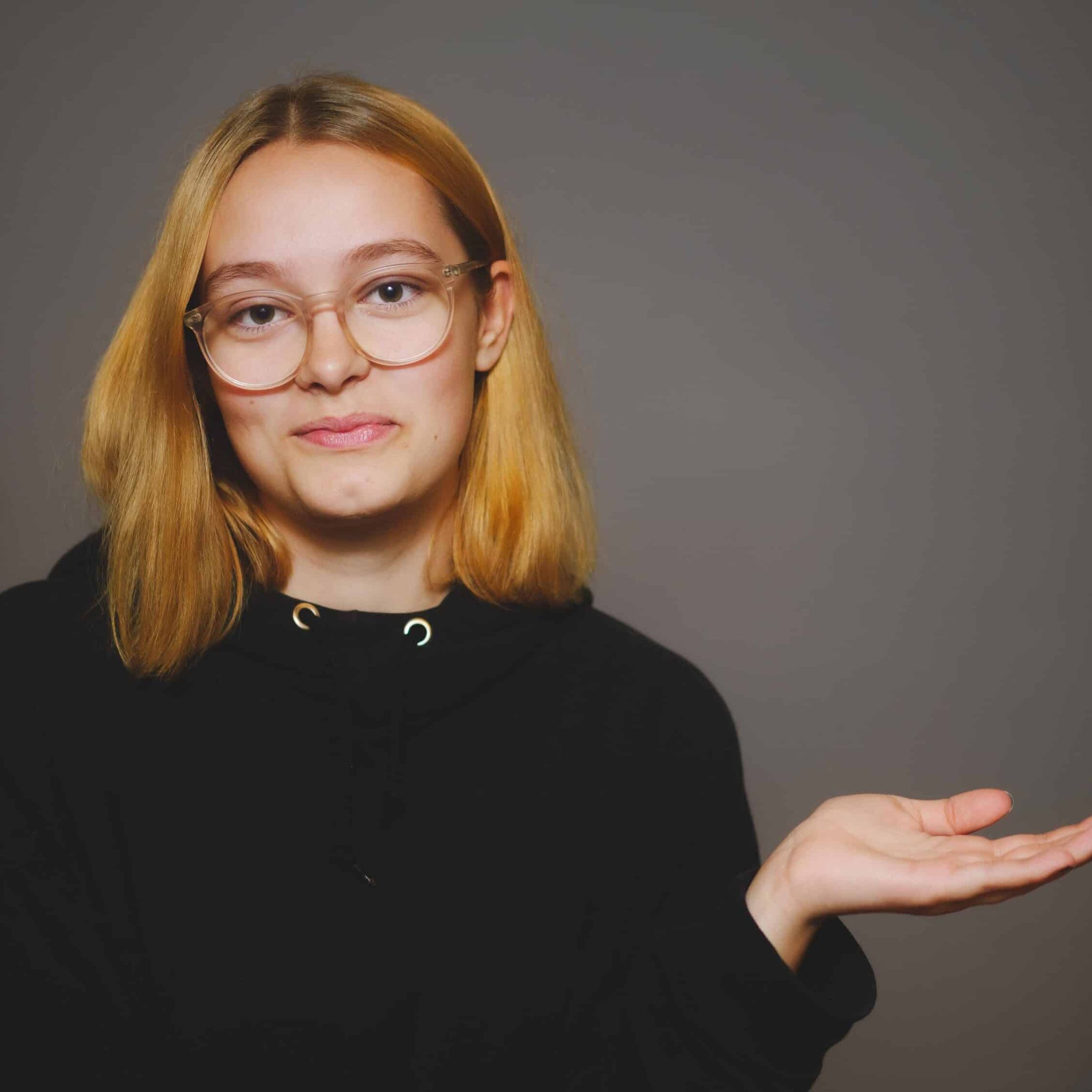 En tjej som gestikulerar åt sidan.