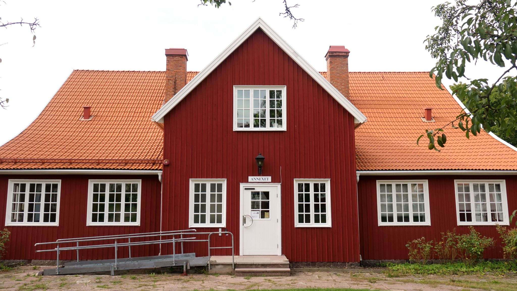 En bild på skolans byggnad kallad "Annexet". Ett rött hus med en rullstolsramp till vänster i bild.