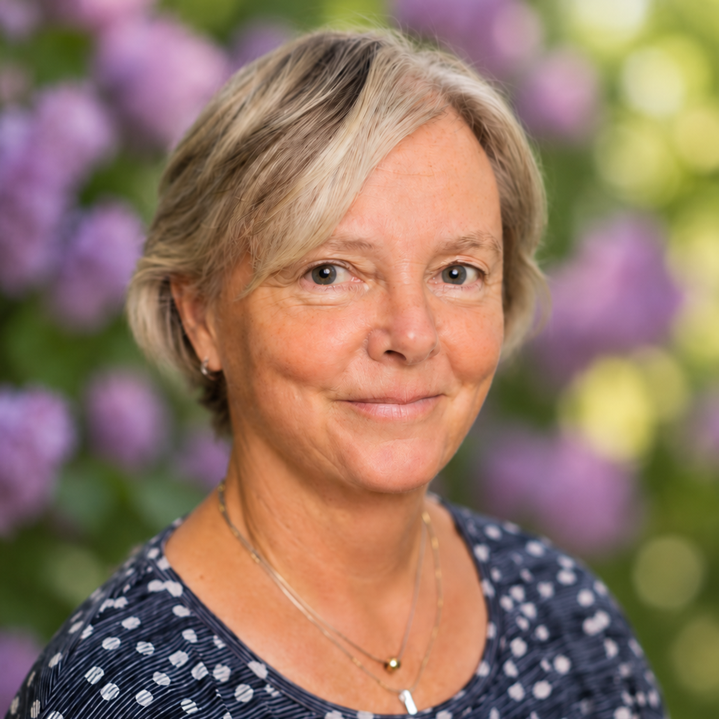 Foto på Monica framför en syrenhäck