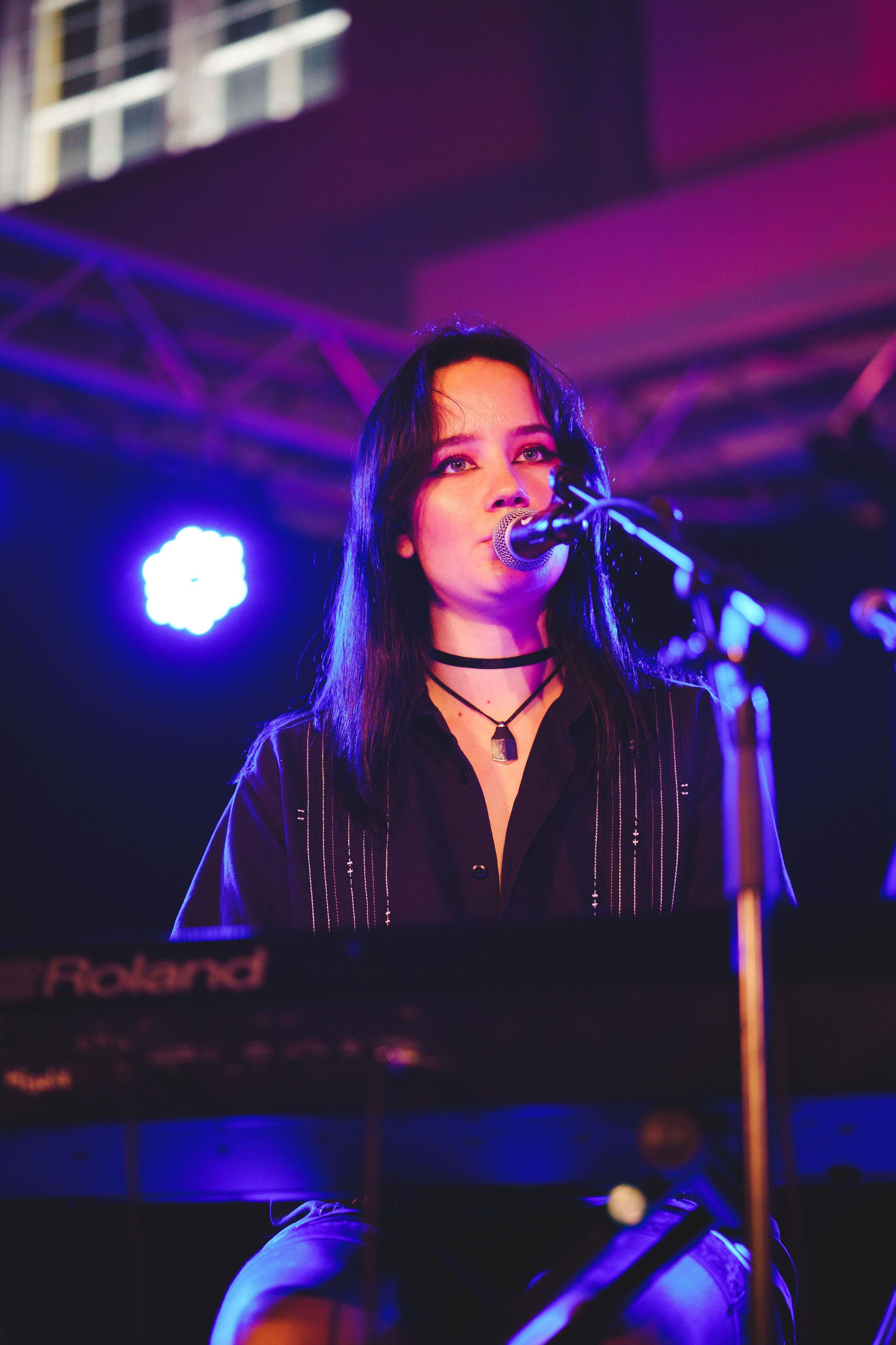 En kvinnlig kör som sjunger på en scen med fin ljussättning