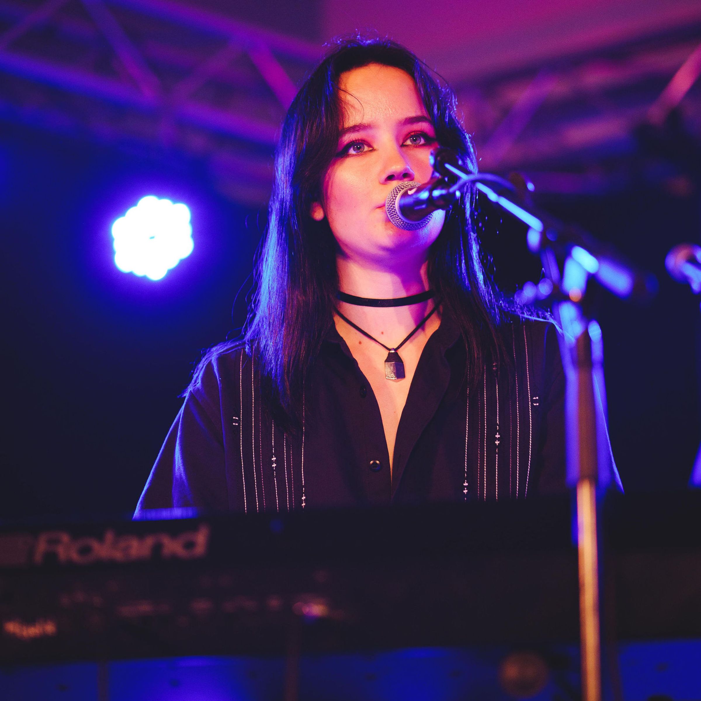 En kvinnlig kör som sjunger på en scen med fin ljussättning