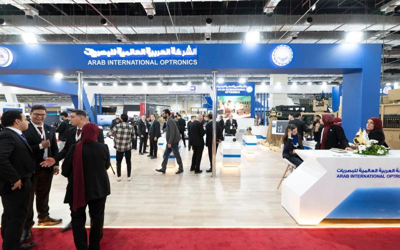Delegates and exhibitors in conversation across a busy international defence exhibition floor