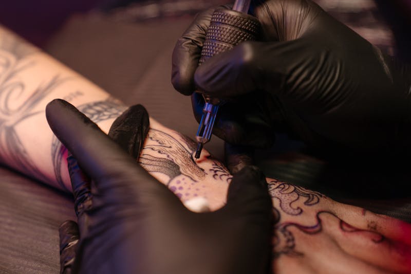 Tattoo artist working on a client during a booked session