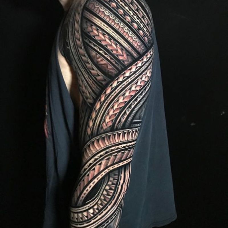 Full sleeve Polynesian tribal tattoo with intricate band patterns and solid blackwork