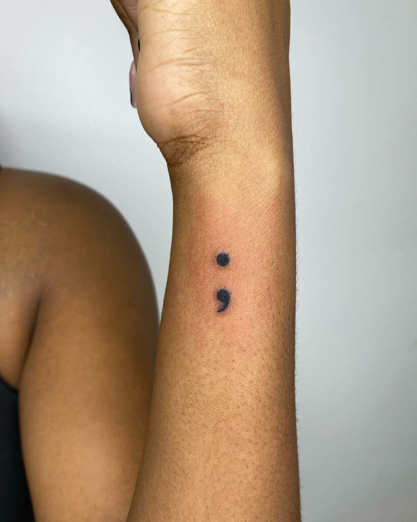 Classic semicolon tattoo on inner wrist — the most iconic placement for mental health awareness