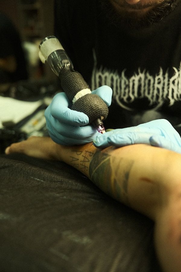 Tattoo artist working on arm tattoo during a pain-managed session
