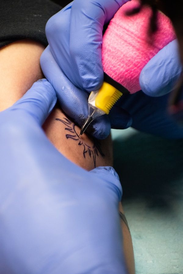 Tattoo artist using modern precision machine on client arm