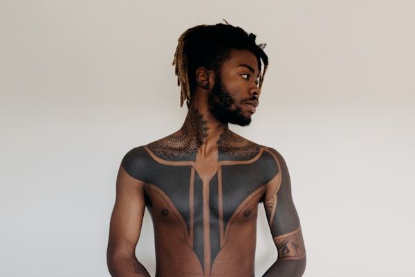 Bold geometric blackwork chest tattoo with symmetrical linear design