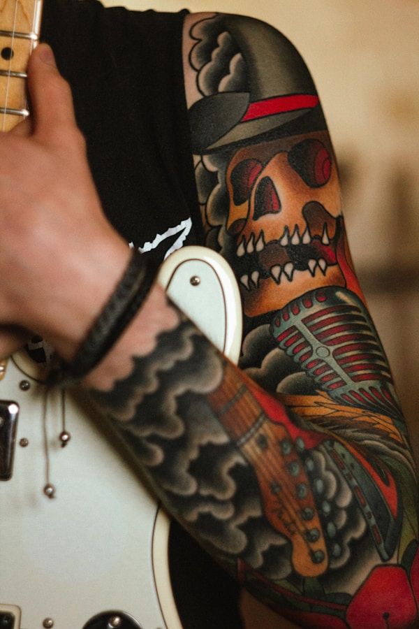 Traditional skull sleeve tattoo with bold red and black old school colour palette on upper arm