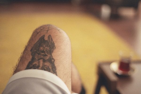 Realistic dog portrait tattoo with lifelike detail on leg