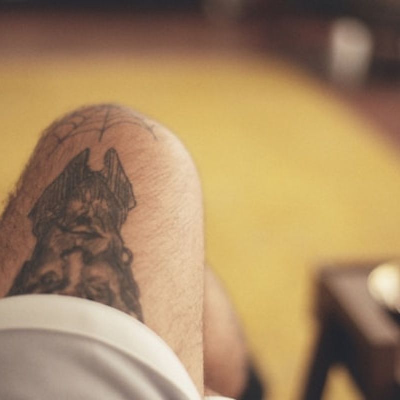 Realistic dog portrait tattoo with lifelike detail on leg