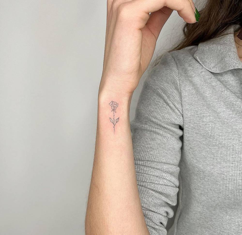 Micro fine-line tattoo with delicate botanical design on inner wrist