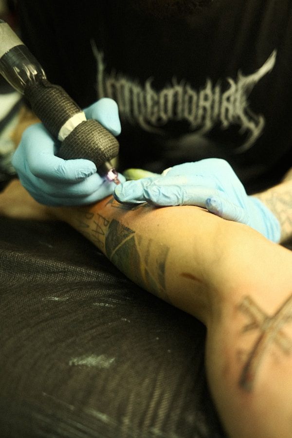 Close-up of tattoo session showing needle technique on forearm