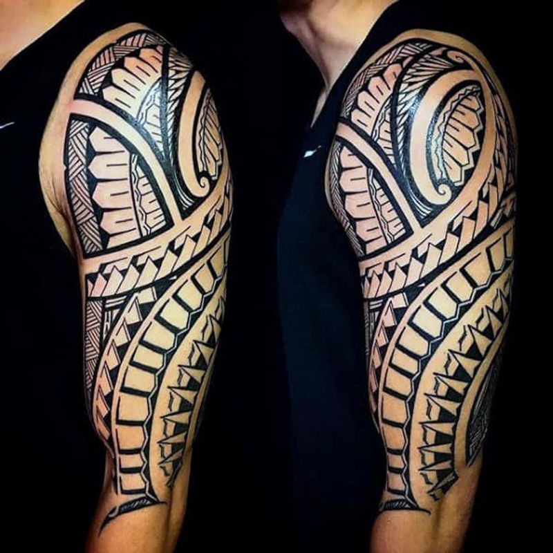 Polynesian tribal half-sleeve tattoo with geometric patterns on upper arm