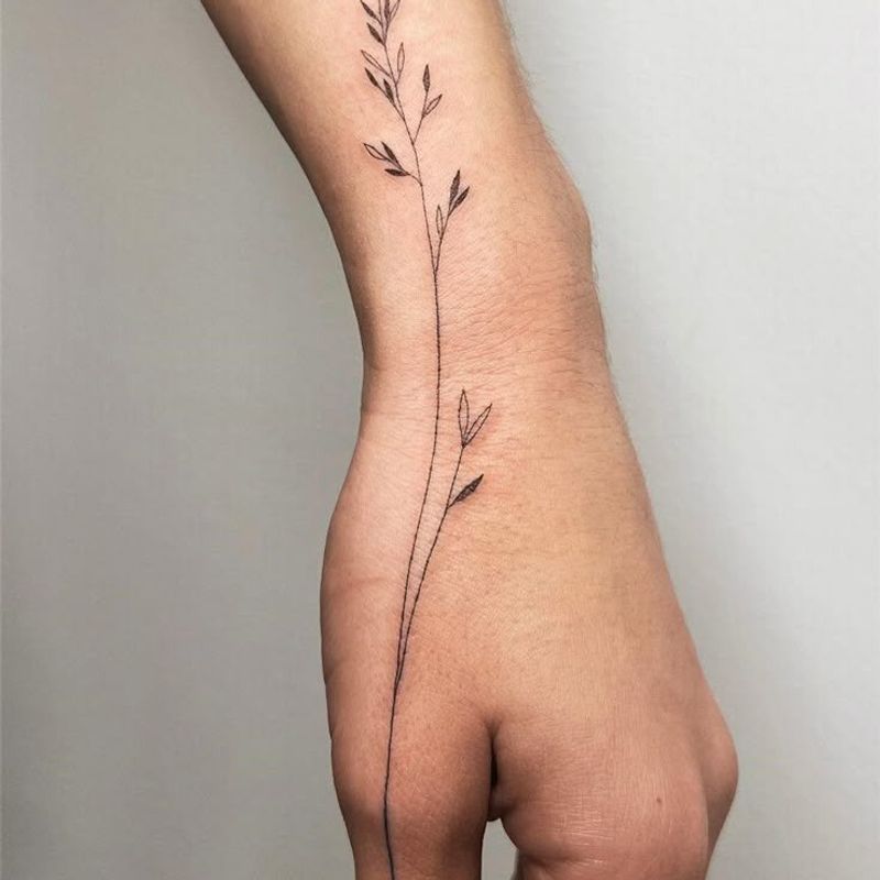 Delicate fine line botanical vine tattoo on wrist and hand