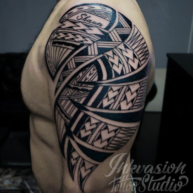 Samoan tribal arm tattoo with traditional Polynesian motifs and bold black fills