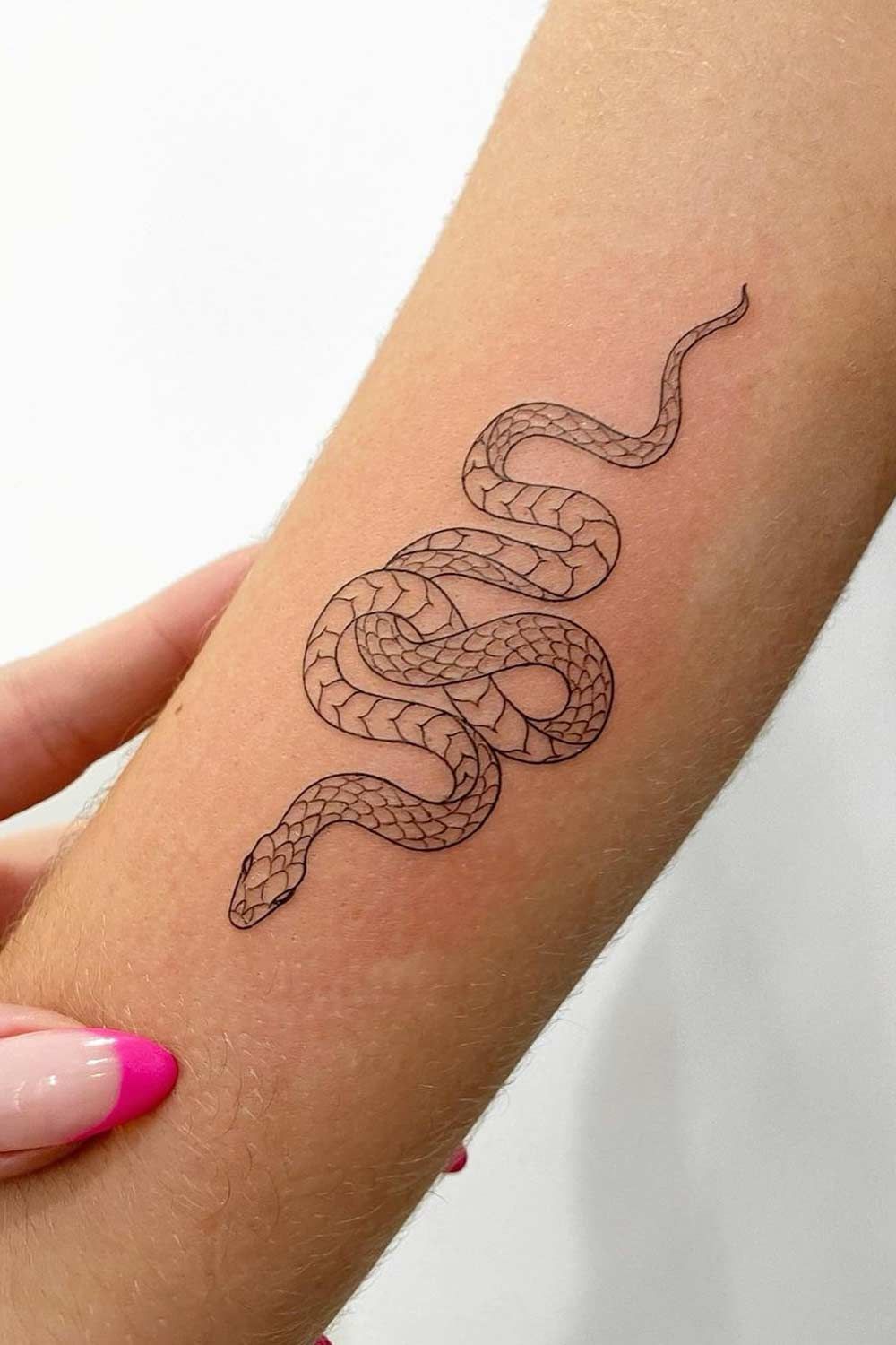 Simple snake tattoo design on forearm with clean black linework