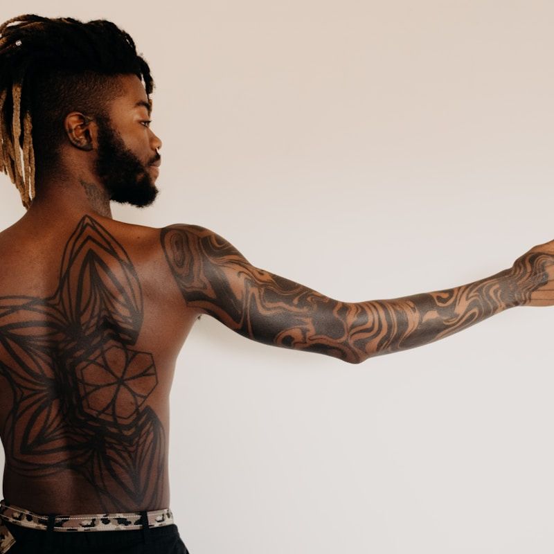 Geometric tattoo sleeve with sacred geometry patterns on back and arm