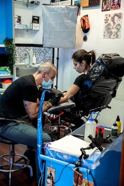 Tattoo artist working with client in studio during pre-tattoo consultation