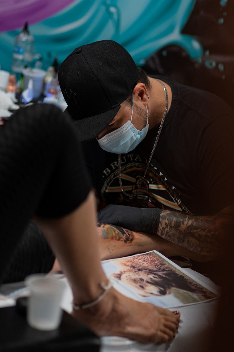 Tattoo artist working on detailed piece demonstrating technique