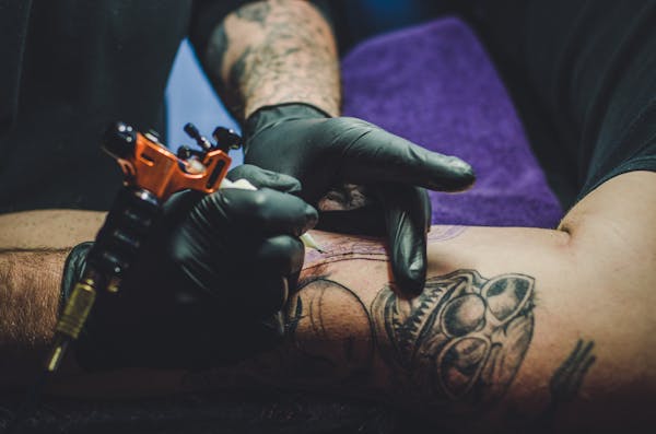 Close-up of tattoo artist working on detailed design — intricate styles like realism and fine line command premium pricing