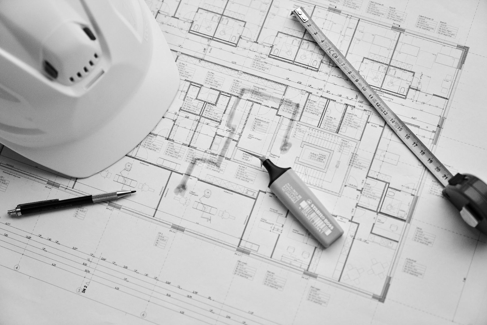 Rinke + Henssler Blogbeitrag Bild – Bauplan mit Helm, Kugelschreiber, Textmarker und Maßband