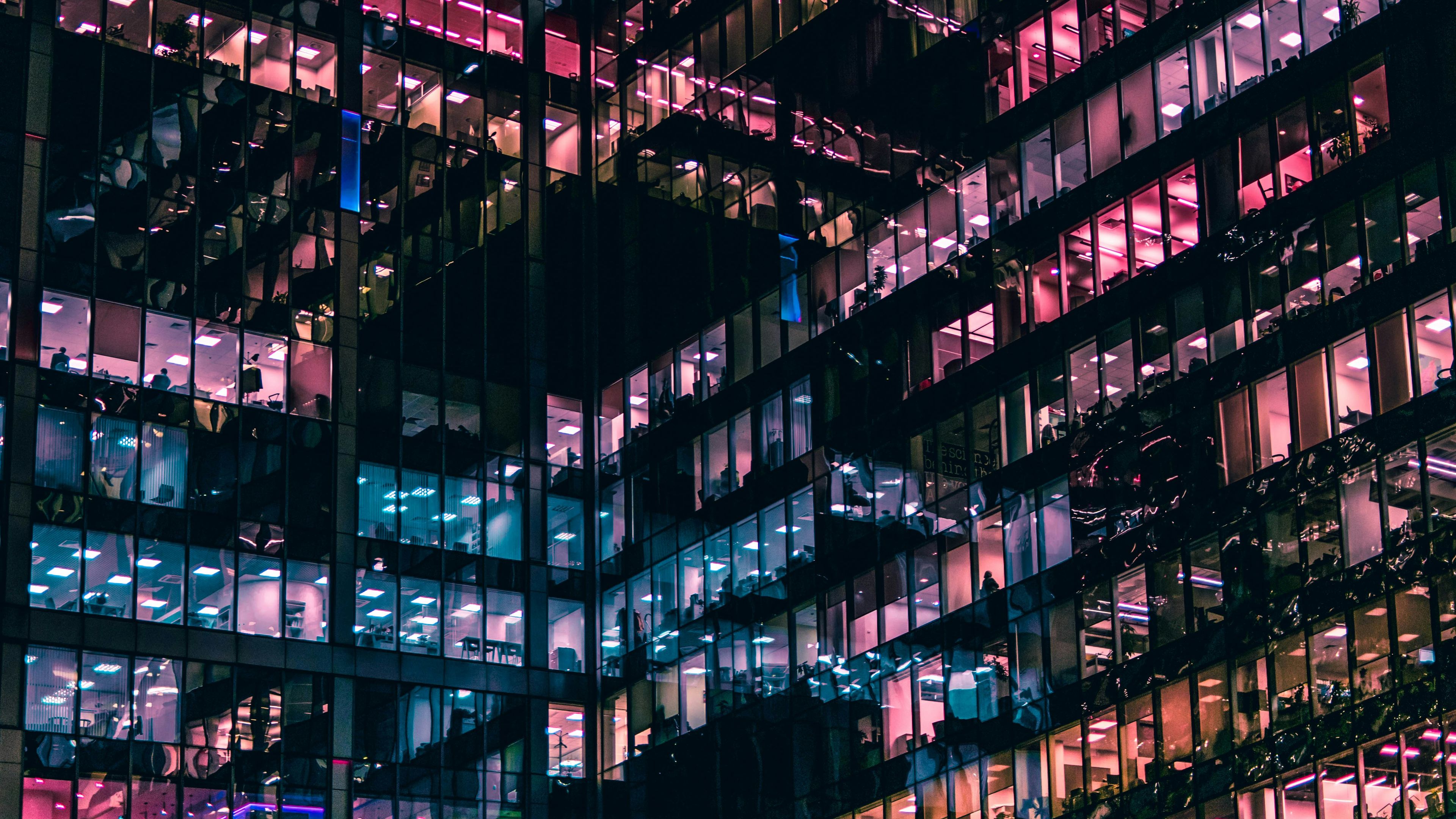 a tall building with lots of windows is lit up at night