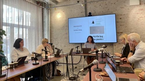 Bilde fra PFU-møte i juni 2026 som viser medlemmer sittende ved møtebordene. I sentrum av bildet PFU-leder Anne Weider Aasen, som sitter foran en skjerm som viser hvilken klagesak som behandles.