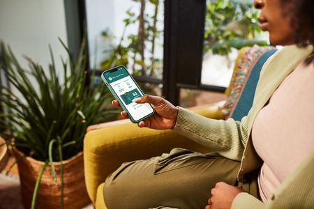 a woman is sitting in a chair holding a cell phone .