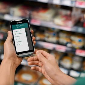 a person is holding a zebra phone in their hands in a grocery store .