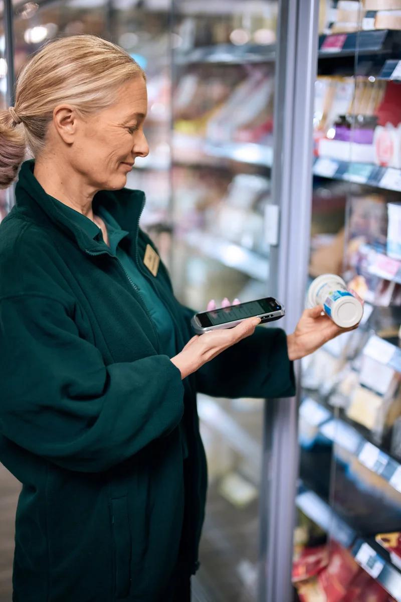 Supermarket worker printing a label from a portable printer