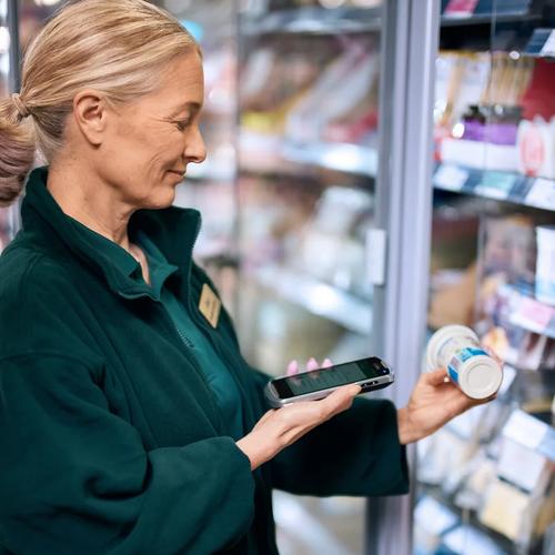 Supermarket worker printing a label from a portable printer