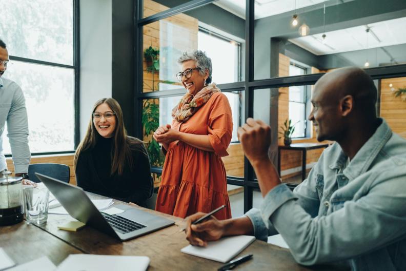 Two women in an office meeting smiling