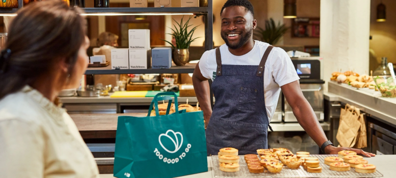 Man smiling behind a bakery counter