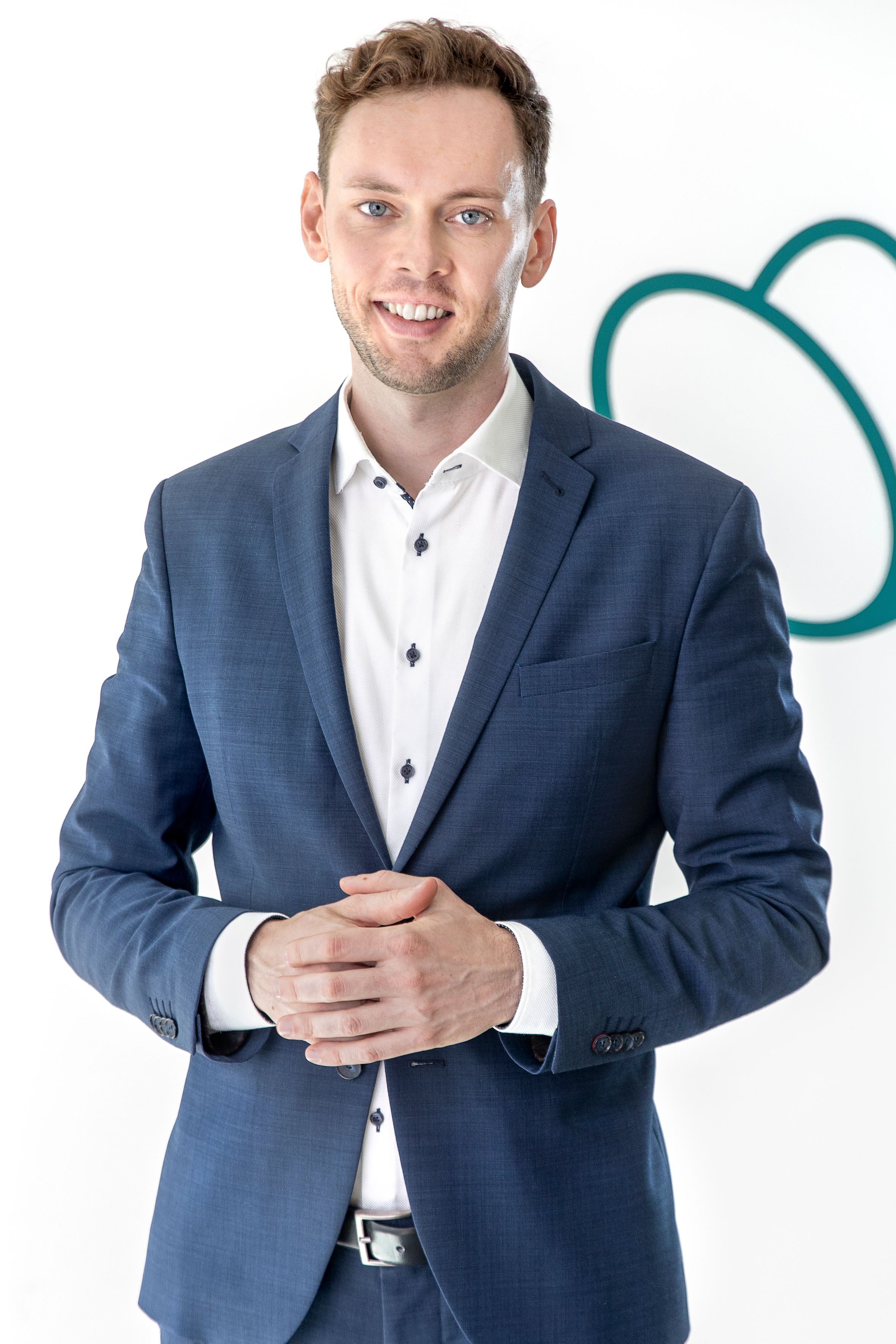 a man is standing with his arms crossed in front of a heart icon .