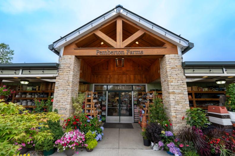 Pemberton Farms store entrance, adorned with various colorful plants and flowers.