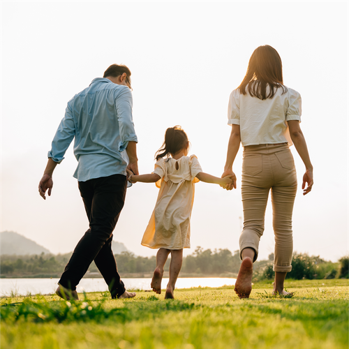 a family is walking their dog in a field .