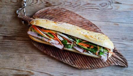 Pork rib stir-fry with green vegetables, red chilies, and cashews, served on a white plate with red chopsticks.