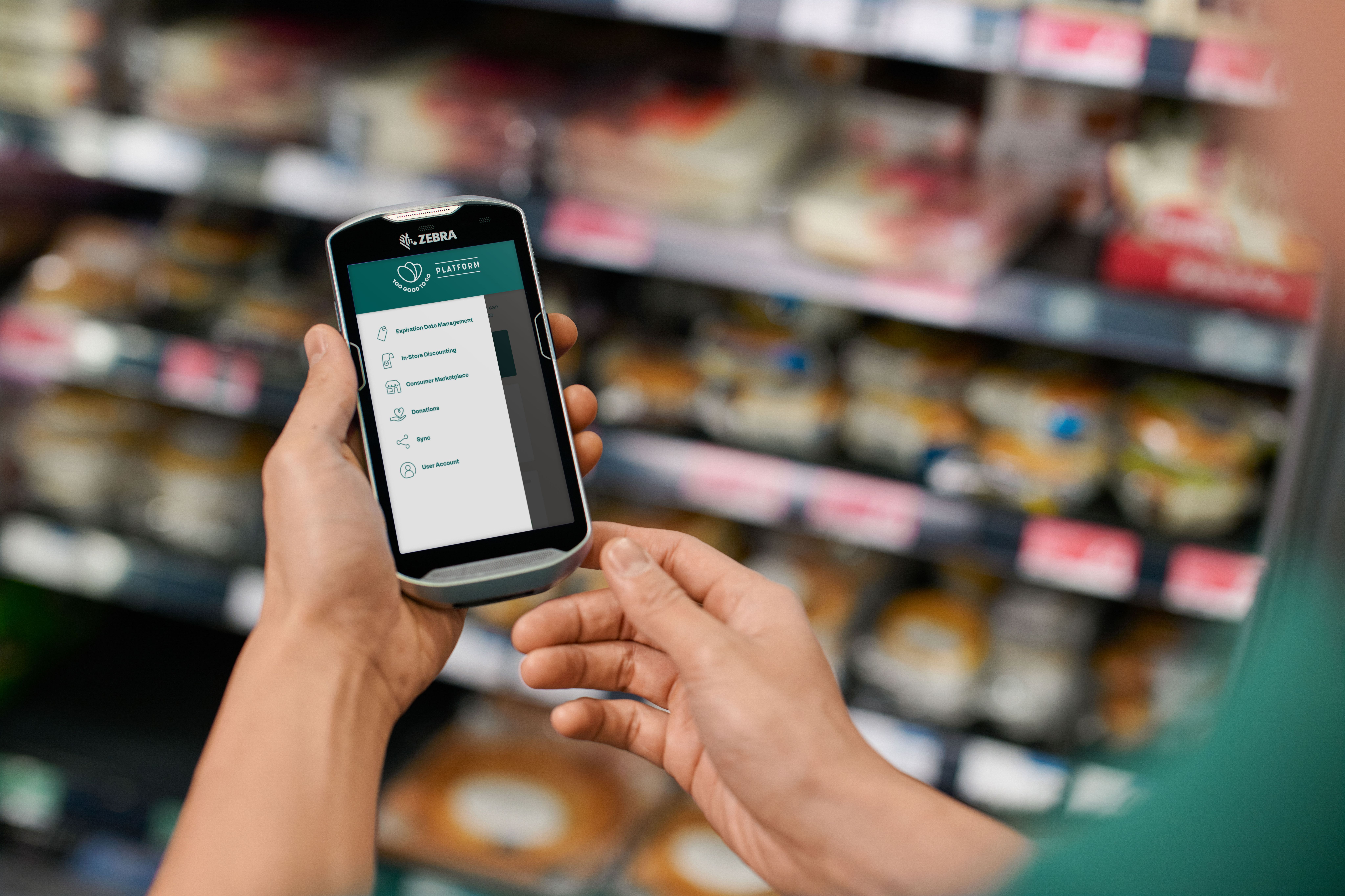 a person is holding a cell phone in their hand in a grocery store .