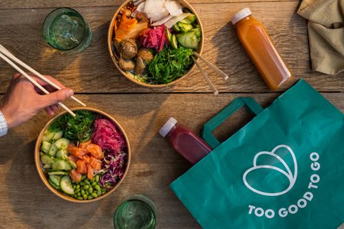 Poke bowls and juice bottles on a wooden counter top