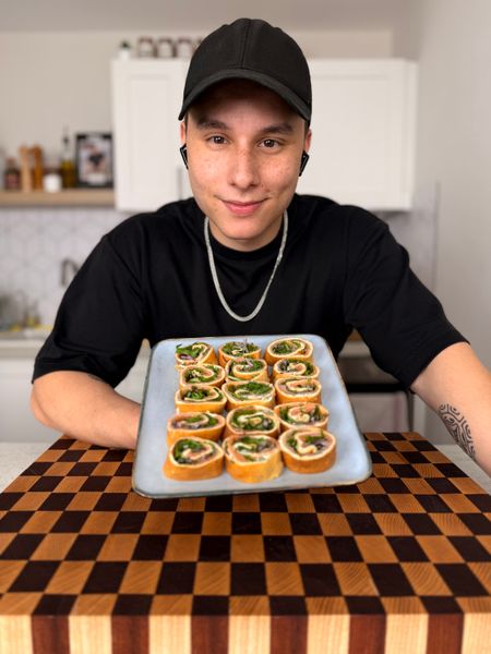 Théo lignani in a black hat holds a tray of food