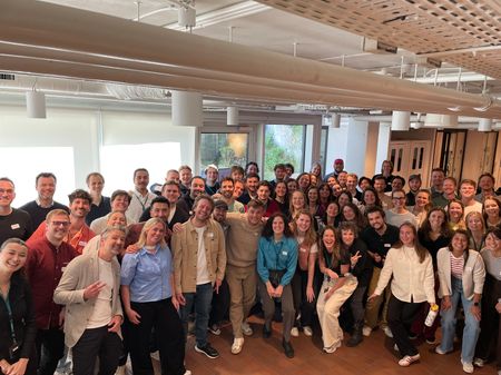 a large group of people are posing for a picture in a room .
