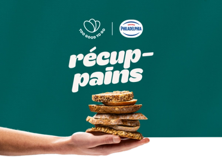 a hand holding a stack of slices of bread with a philadelphia logo in the background