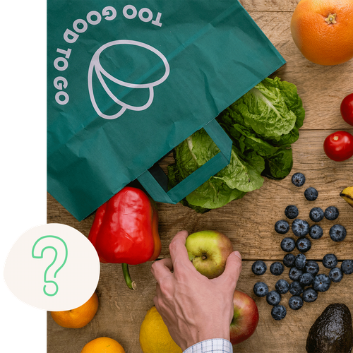a person picking an apple from a bag that says too good to go