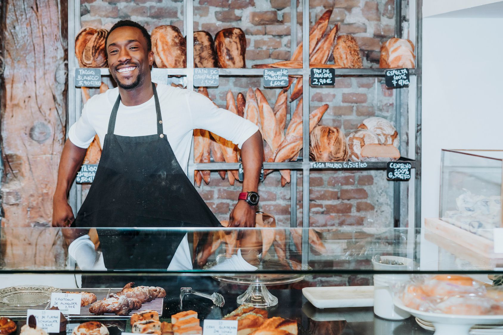 Boulanger debout derrière le comptoir qui renoue son tablier