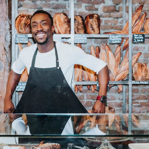 Boulanger debout derrière le comptoir qui renoue son tablier