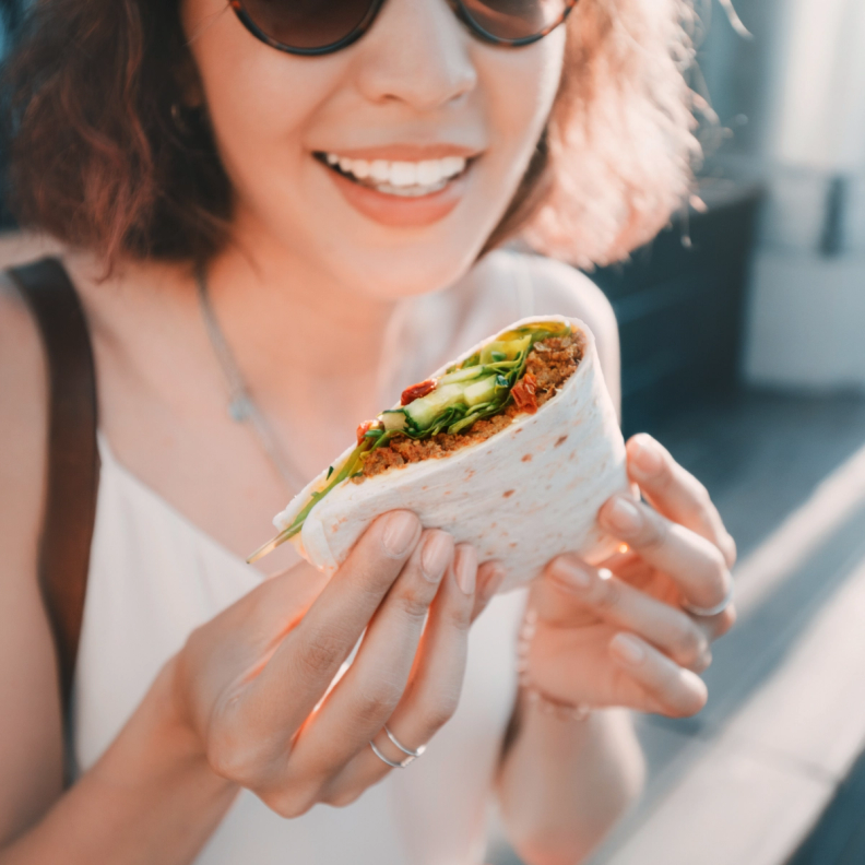 Woman in sunglasses holding a quesadilla