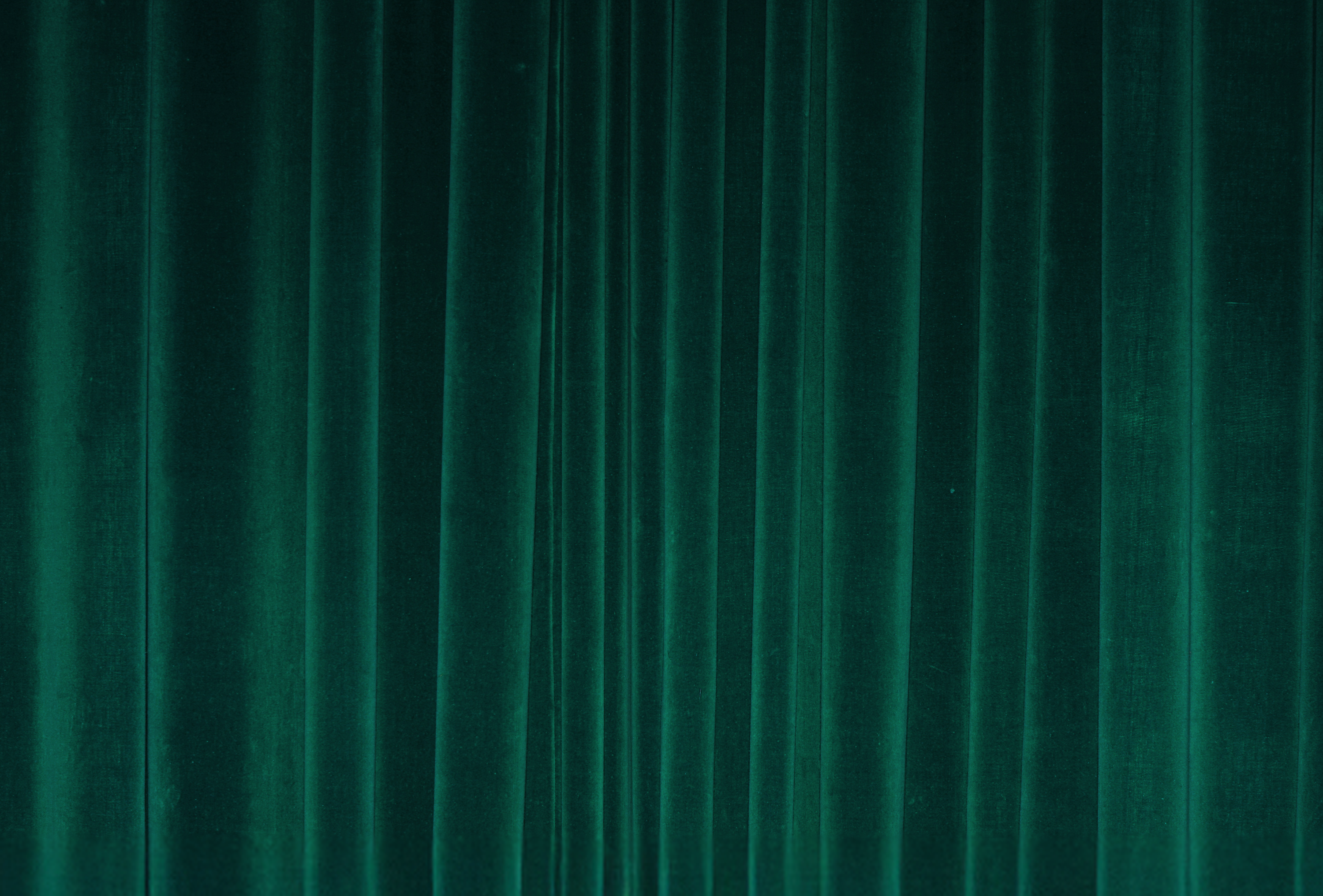 Emerald green velvet curtain with vertical folds.